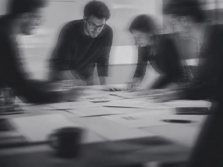 Atelier de conception autour d’une table couverte de maquettes